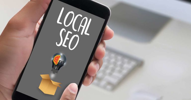 person holding mobile phone with the words local seo on it